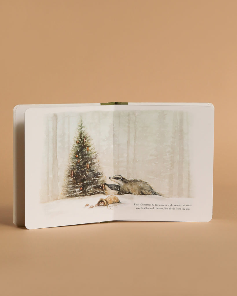 An open copy of "Our Little Adventure at Christmas (Baby's first Christmas)" reveals a badger and fox cub by a decorated tree in a snowy forest, making this beige board book a charming holiday gift for toddlers.