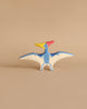 Handmade Holztiger Wooden Dinosaur Set pterodactyl toy with a blue body, white wing undersides with blue spots, and a red and yellow head, perfect for imaginative play.