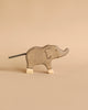 A simple wooden elephant with carved details and a short black tail stands on a beige background. Part of the Holztiger Handmade Wooden Safari Animals Set, it showcases signature craftsmanship and light-colored feet.