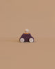 The Lubulona Wooden Car with Figure - Plum features a purple body, light wooden wheels, and a round peg figure—a charming minimalist toy ideal for anyone looking for eco-friendly kids toys.