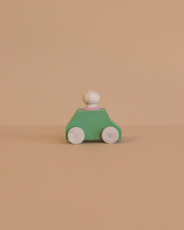The Lubulona Wooden Car with Figure - Mint is a small, minimalist wooden toy car featuring a mint green body, white wheels, and a round white peg driver—an ideal eco-friendly kids toy set against a plain beige background.