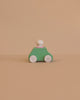 The Lubulona Wooden Car with Figure - Mint is a small, minimalist wooden toy car featuring a mint green body, white wheels, and a round white peg driver—an ideal eco-friendly kids toy set against a plain beige background.