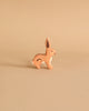 A Holztiger Handmade Wooden Farm Animals Set figurine of a brown rabbit standing in profile.