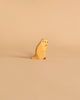 A small handcrafted wooden figure of a meerkat stands upright against a light beige background. The Holztiger Groundhog is crafted simply, with minimal details to represent the meerkat's eyes, nose, and limbs. Made in Europe, it exudes charm and simplicity.