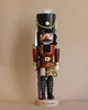 Introducing the Christian Ulbricht Nutcracker - Toy Soldier Limited Edition 5000, a traditional wooden nutcracker crafted as a toy soldier. This collectible piece features a bushy mustache and dons a classic red and black uniform, complete with a tall hat adorned with a star and feather. It stands upright on an elegant base labeled "Toy Soldier.