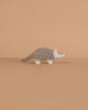 The Holztiger Armadillo is a small, gray wooden figurine with black spots and a white face, handcrafted in Europe, capturing the charm and quality of classic HOLZTIGER toys.