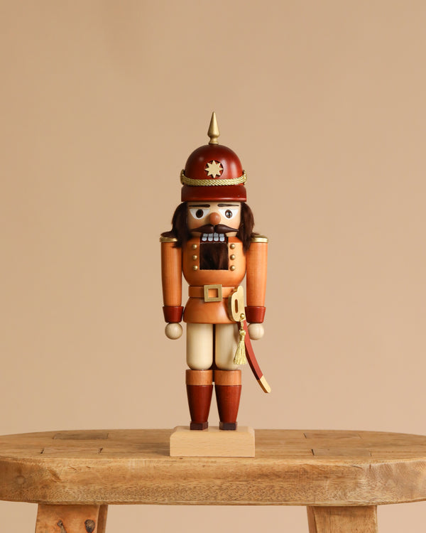 The Christian Ulbricht Collectible Wooden Nutcracker - Policeman stands upright on a wooden stool against a plain beige background.