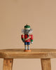 A Christian Ulbricht Collectible Wooden Nutcracker - Mouse King stands on a wooden stool against a plain beige background.
