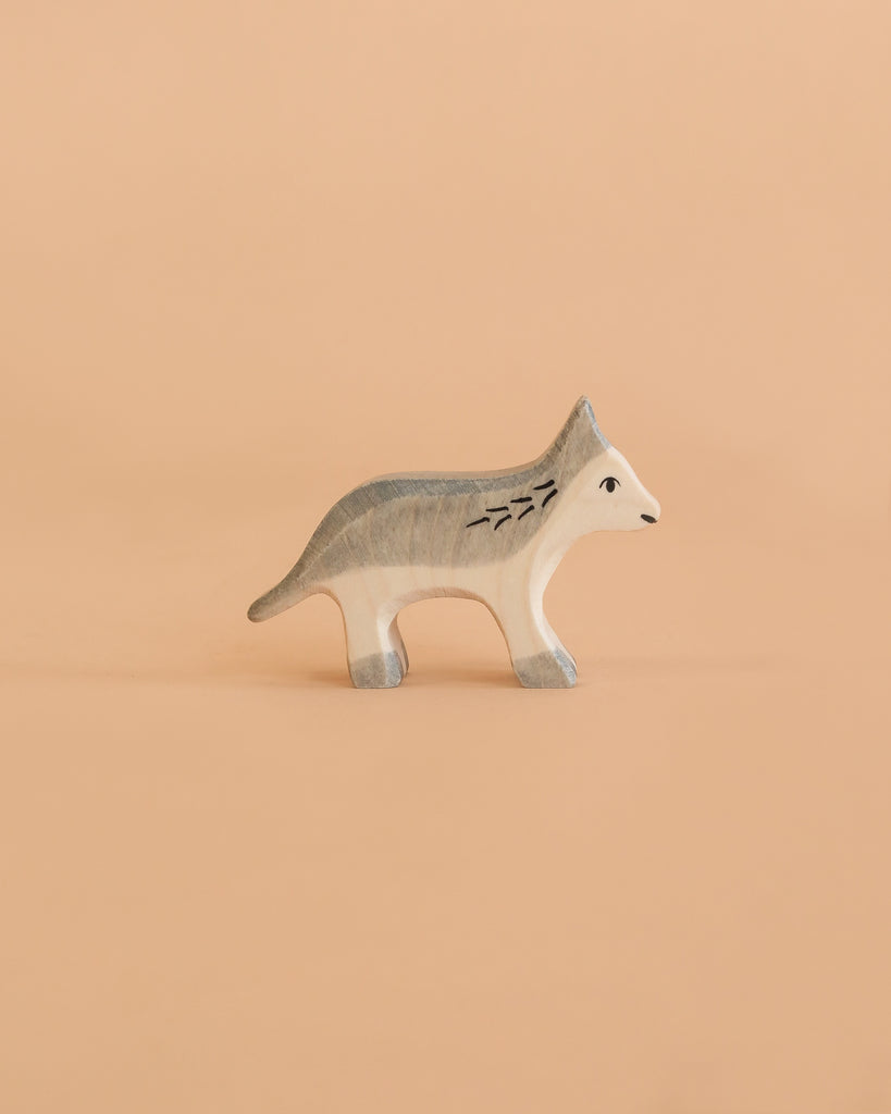 A Holztiger Handmade Wooden Woodland Animals Set figure, handcrafted from wood as a wolf with stylized grey and white painted markings, perfect for imaginative play.