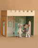 Two small mice from the Maileg Royal Ballet Set stand hand in hand before a charming castle hall backdrop, featuring arched windows and detailed interior decor.