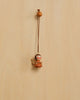 The Christian Ulbricht Ornament - Angel (Natural) is a small wooden angel with painted red cheeks, hanging from a brown string. Made in Germany, this decoration contains small parts and may pose a choking hazard.