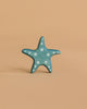 A small, blue starfish figurine with white polka dots stands upright against a light beige background—part of the Handmade Holzwald Underwater World Set.