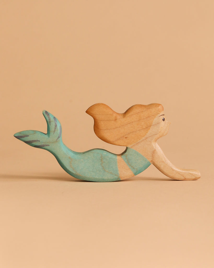 The Handmade Holzwald Mermaid Set features a wooden mermaid figurine with a teal tail and long, wavy, light brown hair, displayed on a plain beige background.