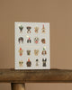 The Party Pups Birthday Card features illustrated dogs in party hats and accessories, arranged in four rows on a plain background. "Happy Birthday" is printed in metallic gold foil at the center, with a blank interior for your message.