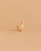 The Handmade Holzwald Gosling, a small wooden toy duck with orange beak and feet, stands on a light beige background—ideal for imaginative play and a delightful addition to any sustainable toy collection.