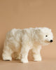 A fluffy white bear-shaped **Polar Bear Cub Stuffed Animal** with a realistic furry texture, black eyes, and nose, positioned against a plain beige background.