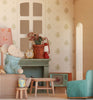 The Maileg Fully Furnished Dollhouse Set + Surprise Gift features a toy mouse in a blue sweater sitting on a sofa in a cozy, vintage-style miniature living room complete with a lamp, clock, table, plant, and TV.