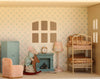 Transform your playtime with the Maileg Fully Furnished Dollhouse Set + Surprise Gift, featuring an adorable toy mouse on a rocking horse, a cozy bunk bed, a blue cabinet, a pink chair, and warm lighting from an elegant lamp. The room is perfectly detailed with a clock on the mantle and beautifully patterned wallpaper surrounding the window—ideal inspiration for miniature enthusiasts and those who love assembling dollhouse scenes.