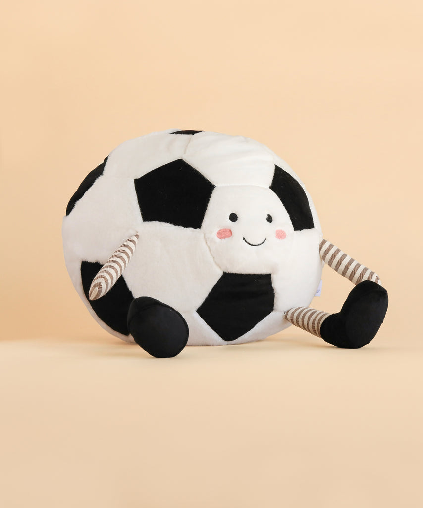 Plush toy shaped like a large soccer ball with a smiling face, striped arms, and black feet, set against a plain beige background—meet the playful Mon Ami Soccer Ball Set.