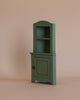 Maileg Little Sister’s Kitchen Set featuring a miniature sage green wooden hutch with an open shelf above a cupboard door.