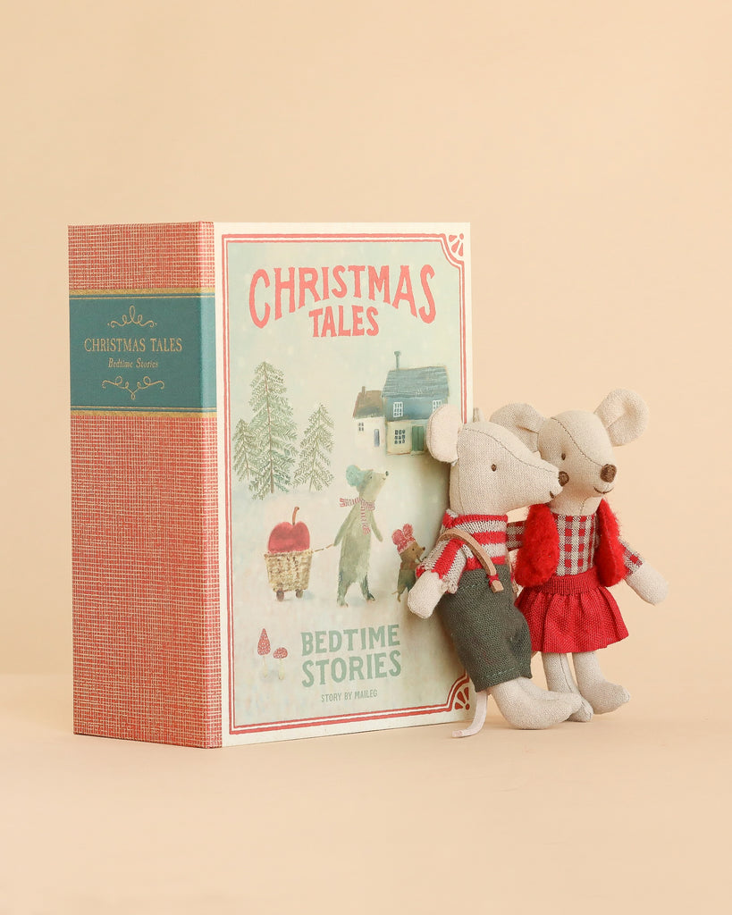 Maileg Christmas Mice Set featuring two twin mice standing next to a decorative book-shaped box titled “Christmas Tales Bedtime Stories” with a winter illustration.