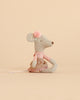 A Maileg Suitcasa Furnished Set mouse toy wearing a pink polka-dot top, a shimmery pleated skirt, and a pink pom-pom headband.