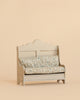 The Maileg Kitchen Bench, Mouse - Light Sand is a small wooden bench featuring a decorative backrest and soft, floral-patterned cushions, set against a plain beige background to create an inviting and cosy atmosphere.