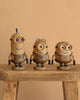 The Boyhood Minions Kevin, Small wooden figurine stands on a rustic European FSC White Oak stool against a beige background, showcasing unique features like distinctive eyes and hair details.