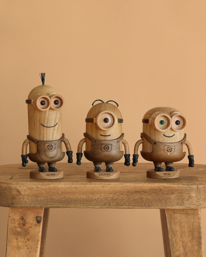 The Boyhood Minions Kevin, Small wooden figurine stands on a rustic European FSC White Oak stool against a beige background, showcasing unique features like distinctive eyes and hair details.