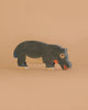 The Holztiger Handmade Wooden Safari Animals Set features a handcrafted hippopotamus toy made from maple and beech wood, painted in dark gray, white, and orange, shown against a plain beige background.