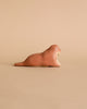 The Handmade Wooden Walrus, brown with simple features, rests on a plain matching background. Crafted like a timeless toy with child-safe paint, it captures the essence of natural beauty artfully in every detail.