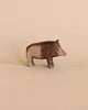 A handcrafted Ostheimer Wild Boar figurine, displayed against a soft beige background, featuring detailed textures and a lifelike pose.
