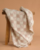 The Organic Cotton Baby Patchwork Blanket - Pink Bows features soft beige and pink embroidery with lace edging, making it perfect as a cozy baby blanket or nursery accent.