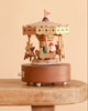 Christmas Carousel Music Box featuring a decorative wooden carousel with miniature reindeer and Santa in a sleigh, resting on a wooden surface.