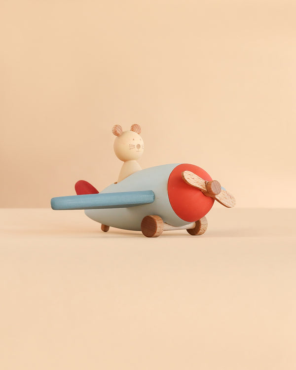 A Sabo Concept Aviator Mouse toy airplane, featuring a wooden design with a red nose, blue wings, and a mouse sitting in the cockpit for imaginative play.