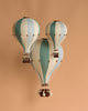 A decorative hot air balloon in mint green and grey hangs against a solid background. This handmade children's room decor features a wooden basket, adding whimsical vintage charm to any space.