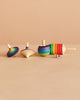 The Spinning Top Champion Learning Set - Rainbow features four vibrant tops of various shapes and sizes, each with bright rainbow stripes, all designed to meet toy safety standards for safe, enjoyable play.