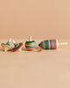 The Mader Spinning Top Champion Learning Set - Striped features five colorful, striped tops in various shapes and sizes—including an elongated one—neatly arranged on a beige surface; all meet toy safety standards to reduce choking hazard risks.
