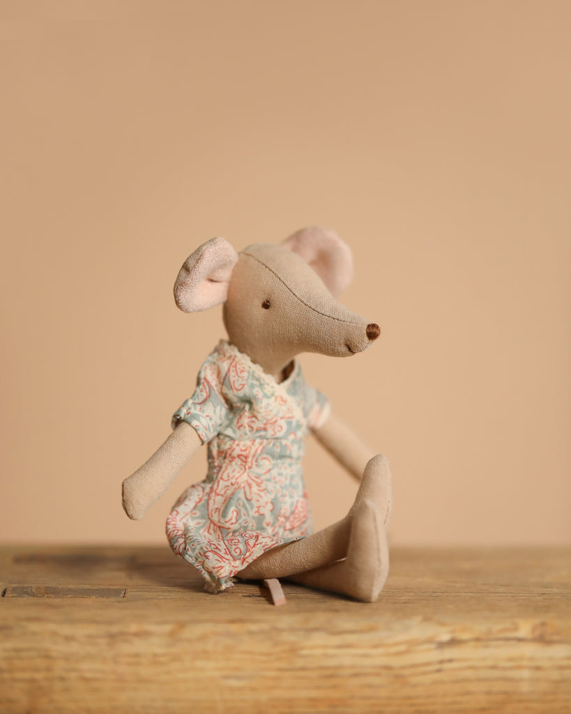 The Maileg Family Theater Set, featuring a mouse in a patterned dress, is displayed on a wooden surface with a plain beige background.