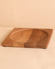 The Walnut Wood Spinning Plate is a square plate with a central round, shallow indent and natural wood grain, crafted to meet toy safety standards. It is displayed on a light beige surface with a matching background.
