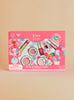 The Klee Naturals Deluxe Makeup Kit - Pink Bubble Fairy features nail polish, lip shimmer, eye shadows, blush, and a brush, all packaged in a pink box with cartoon illustrations.