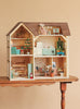 A Maileg Fully Furnished Farmhouse Set featuring a two-story farmhouse dollhouse with an attic, furnished with miniature appliances, furniture, and two mouse figures on a wooden table.
