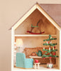 The Maileg Fully Furnished Farmhouse Set features a rocking horse in the attic and a furnished living room with a sofa, armchair, tea set on a small table, and a decorated miniature Christmas tree.