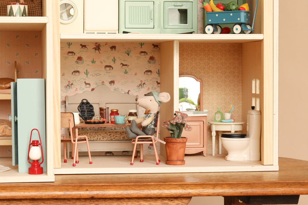 A mouse doll sits at a small table inside a Maileg Fully Furnished Farmhouse Set, with a miniature toilet and vanity nearby.