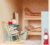 A Maileg Fully Furnished Farmhouse Set bedroom featuring a bunk bed, a blue rocking chair, a small table with an alarm clock and teacup, and a red lantern.