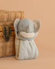 The Maileg Lullaby Friends Elephant, Mini in Iron Grey has patterned ears and a polka-dot body, sitting upright beside a woven basket with a metal latch—a charming newborn gift against a light beige background.