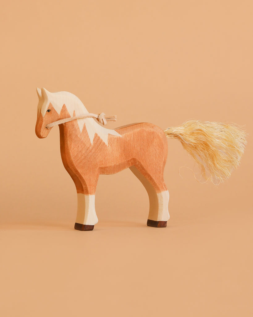 The Bumbu Handmade Wooden Blonde Horse features a light brown body, white mane, and rope tail—an heirloom-quality children’s toy designed for imaginative play.