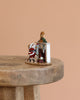 The Wee Forest Folk Tiny Collectible - A Visit From St. Nick (Not a Toy) features a hand-sculpted Santa and mouse by the fireplace with stockings and clock, displayed on a round wooden table—ideal for miniature enthusiasts.
