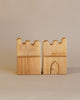 Sentence with product name: Two Ostheimer 2 Parapets With 1 Portal set against a neutral background, featuring a cut-out door and wave-like battlements on top.