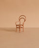A small, light brown Maileg Dining Table & Chairs Set with curved backs and armrests sits on a matching beige surface against a plain beige background, perfectly Mouse Size for your miniature scenes.